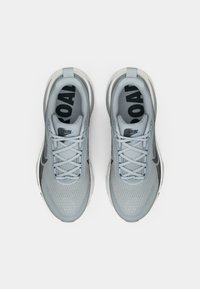 Ανοιχτό γκρι αθλητικά παπούτσια για τρέξιμο με πλέγμα στην επάνω πλευρά, στρογγυλές μύτες, κλείσιμο με κορδόνια και σχέδια στις σόλες που περιλαμβάνουν τις λέξεις "ΤΡΕΞΙΜΟ" και "ΔΡΟΜΟΣ".