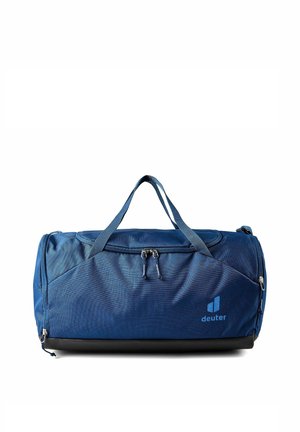 Bolsa de lona azul con dos asas, compartimentos con cremallera y el logo "deuter" en la parte frontal, colocada sobre un fondo blanco.