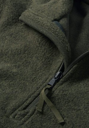 Fleece jas in donkergrijs met een ritssluiting aan de voorkant, met een zachte textuur en een trekband, ontworpen voor warmte en comfort.