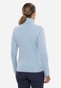 Hellblaues Fleece-Pullover mit langen Ärmeln und hohem Kragen, aus strukturiertem Material und in taillierter Passform. Mit einer Nahtdetails auf der Rückseite.
