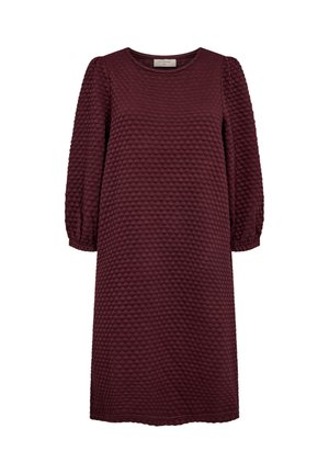 Burgundy klänning i texturerad tyg med rundad halsringning. Har långa, puffiga ärmar och knälång skärning. Subtil mönsterdetaljering genom hela plagget.