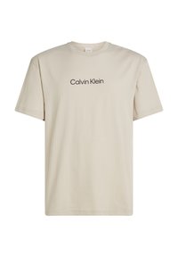 T-shirt in cotone beige con maniche corte, scollatura rotonda e logo nero "Calvin Klein" stampato sul fronte. Vestibilità regolare, design minimalista.