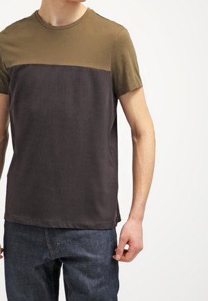 Lyhythihainen T-paita, jossa on väri-block design; yläosa oliivinvihreä ja alaosa tummanharmaa, valmistettu pehmeästä kankaasta.