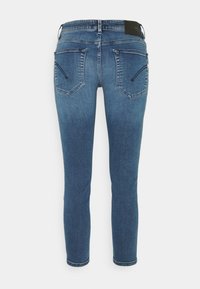Jeans skinny-fit en denim azul medio, con una cintura alta, dos bolsillos traseros con cremalleras y una textura suave.