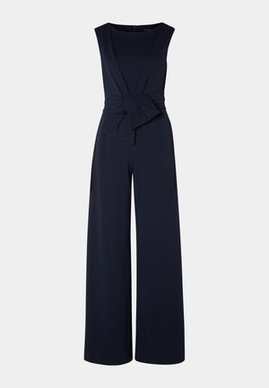 Tutina blu navy con gambe ampie, un corpino aderente e scollatura a V. Presenta un dettaglio di fiocco anteriore e una chiusura con zip sul retro.
