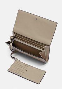 Beżowy skórzany portfel o strukturalnym designie, z wieloma kieszeniami na karty, kieszenią zapinaną na zamek oraz odpinanym organizerem na karty.