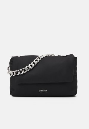Black rectangular handbag with silver chain strap and small Calvin Klein logo on front against white background.