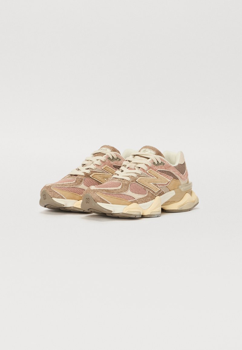 Beige und rosa Mesh-Sneaker mit Suede-Akzenten, strukturierten Überzügen und einer klobigen, hellen Sohle. Verfügt über Schnürsenkel und ein Logo an der Seite.