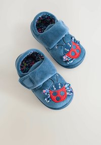 Blå plyssede tøfler med et mariehønedesign, følt krop, blomstermønstret foring og en velcro-rem til justerbar pasform.