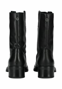 Botas de tobillo de cuero negro con un acabado ligeramente texturizado, punta redonda y un tacón bajo en bloque. Presentan un detalle de logo circular en la parte posterior.