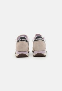 Tenisky Saucony s svrchním materiálem z lehkého béžového semiše, levandulovými akcenty a černým patkem s názvem značky. Plochá gumová podrážka.