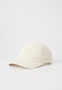 Cappellino da baseball in cotone beige con logo ricamato sul davanti, visiera curvata, fascia regolabile sul retro, texture liscia e dettagli di cucitura sottili.