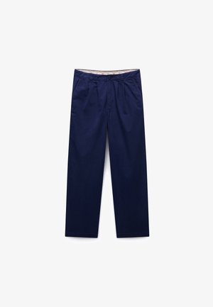 Pantaloni bărbătești bleumarin cu pliuri frontale, buzunare laterale, bucle pentru curea, închidere cu nasturi și talie interioară cu model, așezați pe o suprafață albă.