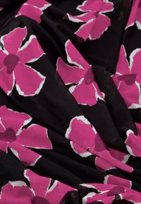 Zwarte stof met grote roze bloemen met witte omrandingen. De textuur lijkt zacht met geplooide rimpels en een gladde afwerking.