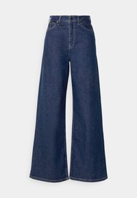 Breda denimjeans i mörkblå. Tillverkade av slitstark bomullstyg. Har en knapp- och dragkedjestängning, frampockets och synlig sömnad.