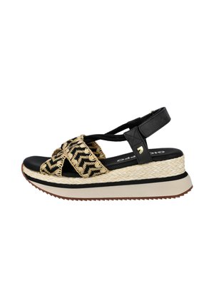 Sandalia de plataforma negra y beige con tiras tejidas en zigzag, soporte para el tobillo y suela de goma estriada para uso casual.