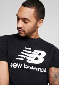 New Balance ESSENTIALS STACKED LOGO  - Camiseta estampada - black