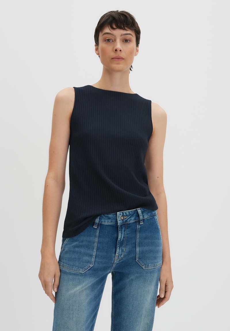 Top senza maniche a coste blu navy con un collo alto, abbinato a jeans diritti azzurri chiari, con cuciture a contrasto e cinque tasche.
