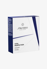 Pudełko z terapią oczu Shiseido Vital Perfection; elegancki design w kolorach białym i ciemnoniebieskim; geometryczne wzory; wyraźne logo; tekst szczegółowo opisujący korzyści produktu.
