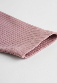Tejido acanalado de color rosa suave con un borde enrollado; presenta una textura fina y sutiles detalles de costura, ideal para llevar cómodamente.