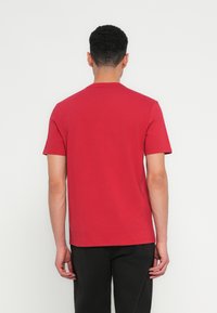 Κόκκινο κοντομάνικο μπλουζάκι από βαμβάκι, με στρογγυλή λαιμόκοψη και κανονική εφαρμογή. Απλό σχέδιο με λεία υφή, χωρίς ορατά σχέδια.