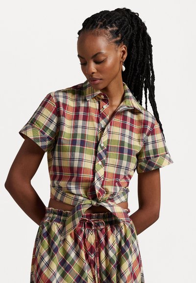 Chemise à manches courtes, col polo, avec un motif à carreaux multicolores en rouge, vert, bleu et jaune ; nouée à la taille, fabriquée en coton.