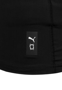 Zwarte sportkleding met een gladde textuur, met een rechthoekig label met het witte Puma-logo en een klauwafbeelding. Nette stiksels zichtbaar.