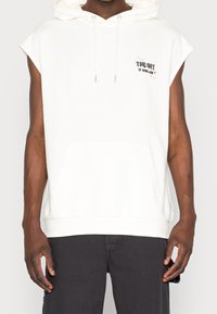 ÄrmLös vit huva sweatshirt i bomull, med en framficka, broderad text på bröstet och en avslappnad passform.