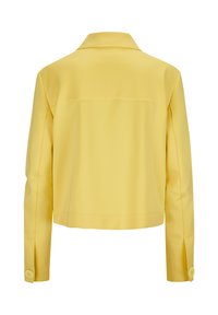 Gelbe cropped Jacke mit flachem Kragen, langen Ärmeln und geknöpften Manschetten. Eleganter Stoff mit glatter, matter Textur. Rückansicht gezeigt.