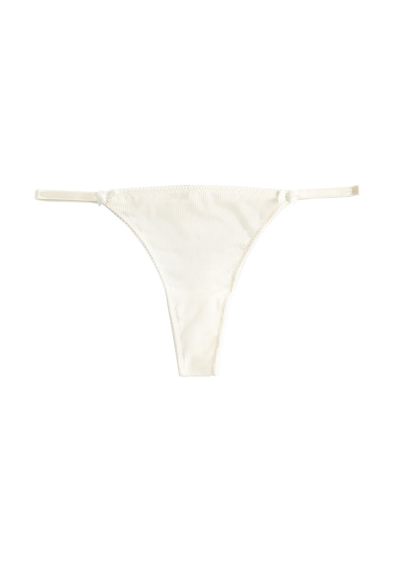 Vit tanga gjord av ett mjukt, strukturerat tyg med tunna sidband och minimal täckning, med en sömlös design och släta kanter.