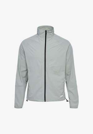 Lichtgrijs jack met een hoge kraag, een rits aan de voorkant, twee borstzakken en een verstelbare zoom. Gekenmerkt door een gladde, waterbestendige stof.