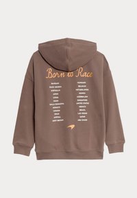 Hnědá mikina s kapucí se středovým textem "Born to Race" v oranžové barvě, pod nímž jsou uvedeny názvy zemí v bílé barvě. Měkká tkanina s uvolněným střihem.