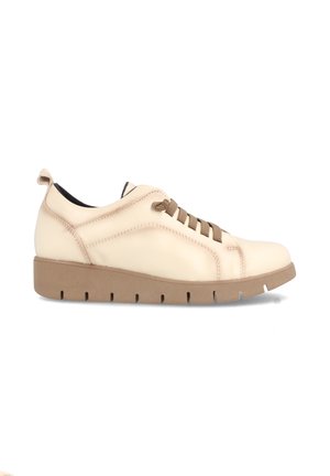 Zapatilla de piel beige con un diseño de perfil bajo, superficie texturizada, cordones marrones y una suela de goma color marrón claro con detalles troquelados.