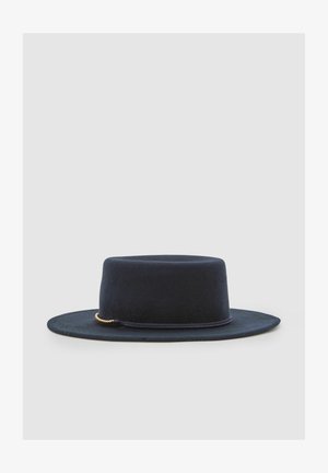 Schwarzer Filzhut mit breiter Krempe und flachem Kopf. Verziert mit einer goldfarbenen Kettenakzent. Glatte Textur und strukturierte Form.