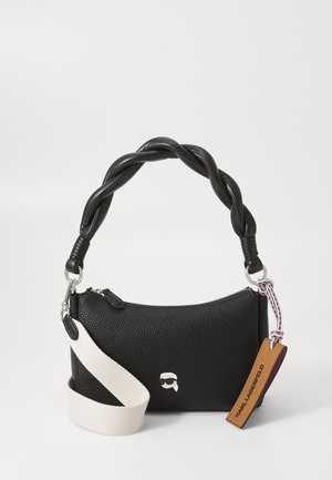 Sac à main en cuir noir texturé avec une anse tressée noire, des finitions argentées et une sangle beige amovible avec une étiquette et un détail de logo.