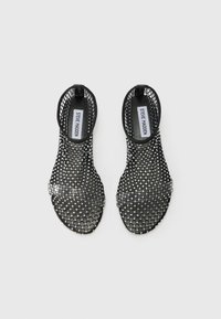Black woven sandals with a mesh design, featuring rhinestone accents and a back ankle strap, open toe, and flat sole.