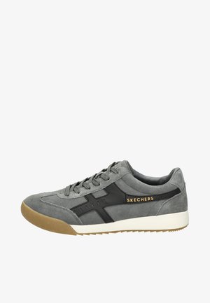 Sneaker grigia in suede con accenti neri e suola in gomma, con lacci frontali, logo sul lato e dettagli testurizzati sulla tomaia.