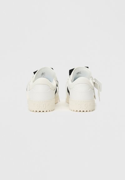 Białe sneakersy z teksturowanej skóry, czarnymi akcentami po bokach i grubą, karbowaną kremową podeszwą. Gumowe detale z logo na podeszwie.