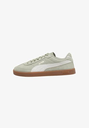 Zapatillas de ante en verde claro con acentos blancos, diseño de cordones y suela de goma marrón. Cuenta con el logo de PUMA en el lateral y en el talón.