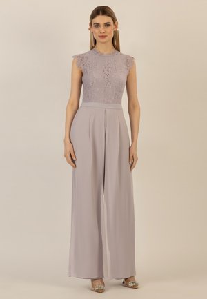 Spitzenoberteil in hellem Lavendel mit kurzen Ärmeln, kombiniert mit hoch taillierten, fließenden Lavendel-Hosen. Verziert mit weicher Textur und Falten.