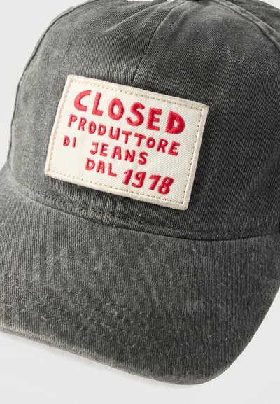 Γκρι καπέλο με ραμμένο λευκό ταμπελάκι που γράφει "CLOSED PRODUTTORE DI JEANS DAL 1978" με κόκκινα γράμματα στο μπροστινό μέρος.
