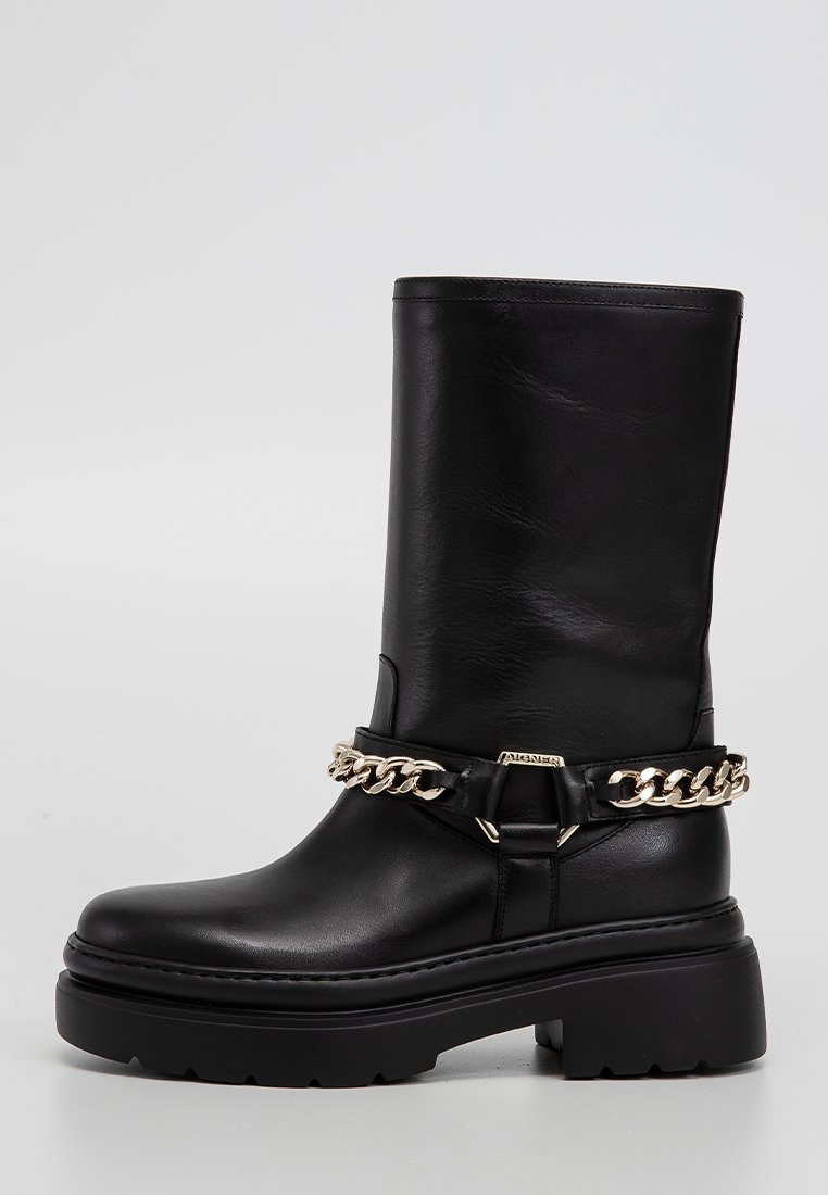 Schwarze Lederstiefelette mit einer klobigen Plateausohle. Verfügt über eine goldene Kettenakzentuierung um den Knöchel und eine glatte Textur.