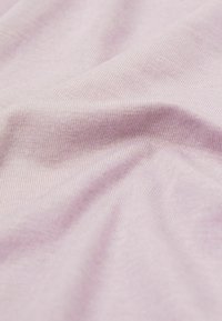 Tissu rose clair avec une texture lisse et un fin côtelé, présentant de subtiles variations de douceur et de brillance.