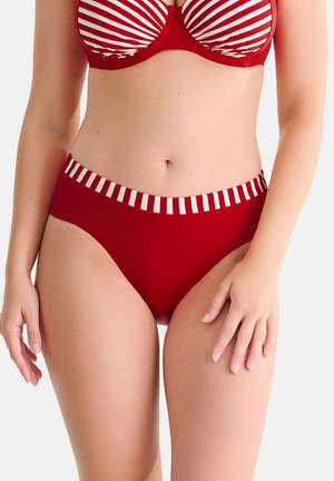 Femme portant un bas de bikini taille haute rouge avec des rayures blanches verticales sur la ceinture, assorti d'un haut de bikini rouge et blanc rayé.