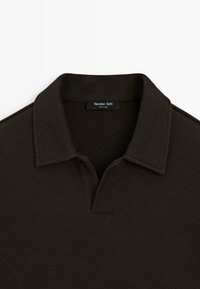Polo shirt marrone scuro realizzato in tessuto a trama. Presenta un colletto, una chiusura a due bottoni e un'etichetta con la scritta "Massimo Dutti."