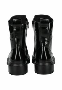 Botines de charol negro con un acabado brillante, que cuentan con una suela de plataforma resistente y cremalleras laterales para facilitar su uso.
