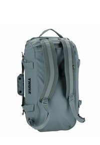 Zaino Thule grigio con spallacci imbottiti, manico superiore e molteplici scomparti, realizzato in tessuto resistente con un design elegante.