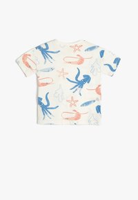 Kortærmet t-shirt i cremefarvet stof med et farverigt marinelivsmønster, herunder blæksprutter, fisk og rejer i blå og koralfarvede toner.