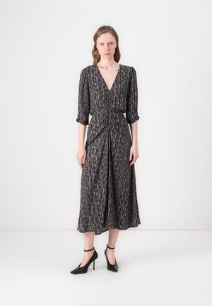Dark patterned midi dress with a deep V-neck, ruched waist, three-quarter sleeves, and flowing skirt. Paired with black heeled shoes.