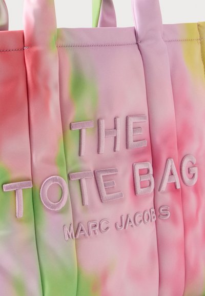 Sac tote tie-dye pastel aux nuances roses, vertes et jaunes, brodé avec "THE TOTE BAG MARC JACOBS" en lettres en relief.